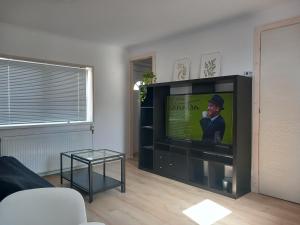 a living room with a flat screen tv in a living room at Zárda utcai Apartman in Kaposvár