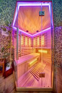 una sauna vuota con luci viola in una stanza di Home Away From Home Apartment 538 a Smoljan