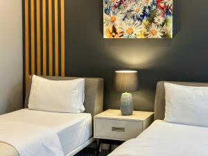 une chambre d'hôtel avec deux lits et une table avec une lampe dans l'établissement Silver 39 Corner Hotel, à Tbilissi