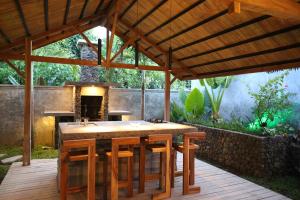 una cocina al aire libre con una gran mesa de madera en Beach Villa Ayu at Sumberkima Beach, en Banyuwedang