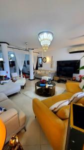 un ampio soggiorno con divani e lampadario a braccio di Ulah Properties a Mombasa