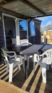 a picnic table and two chairs on a deck at LE RHUYS, mobil home cosy proche des plages in Sarzeau