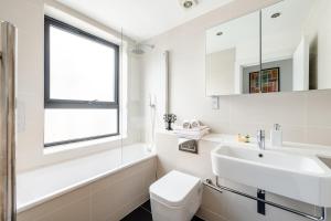 a white bathroom with a sink and a toilet at Stunning 1 Bed apartment Kings Cross/St Pancras Farringdon in London