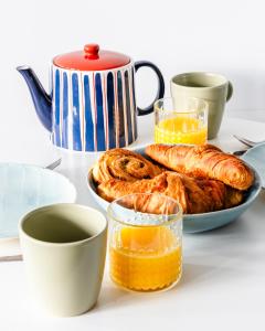 a table with a plate of croissants and orange juice at Stunning 1 Bed apartment Kings Cross/St Pancras Farringdon in London