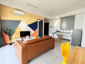 a living room with a couch and a kitchen at Cozy Minimalist Suite at Georgetown by SuperStay in Jelutong