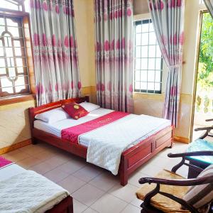 um quarto com uma cama num quarto com janelas em GRAD Hoa Do Hotel em Xuân Ðài