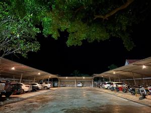 a parking lot at night with cars parked in it at Pilatus Apartment in Loei