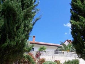 a white house with a fence and trees at B&B Sciarammola in Patti