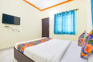 a bedroom with a bed and a flat screen tv at FabExpress Shanel Beachside Resort in Baga