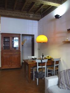 comedor con mesa y luz amarilla en Casa Lorena, en Florencia