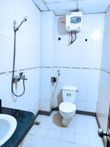 a bathroom with a toilet and a shower and a sink at GRAD Hoa Do Hotel in Xuân Ðài