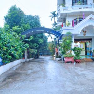 uma rua molhada com um arco azul ao lado de um edifício em GRAD Hoa Do Hotel em Xuân Ðài