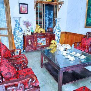 uma sala de estar com cadeiras vermelhas e uma mesa em GRAD Hoa Do Hotel em Xuân Ðài
