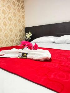 Hotel Boutique Casa Dorada في نيفا: سرير عليه مناشف حمراء وبيضاء وورد