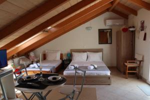1 dormitorio en el ático con 2 camas y mesa en AB Preveza Seaside Attic Sofita -15 Meters Over the Sea, en Preveza