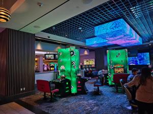 una sala de juegos con personas jugando videojuegos en Coolest bar hoping Linq Casino Hotel Strip Las Vegas, en Las Vegas