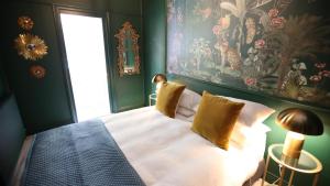 a bedroom with a bed with a painting on the wall at Victoria and Albert Guesthouse in Mount Victoria