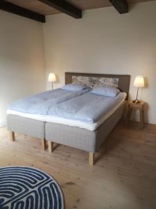 a bedroom with a large bed with two lamps on tables at Foxhouse in Præstø