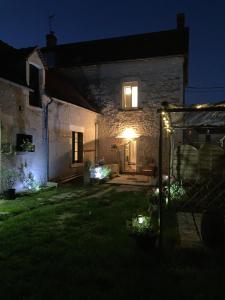 an old stone house with a lit up yard at night at Coup de cœur en Brenne in Martizay
