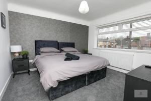 a bedroom with a large bed and a window at Newly Renovated 3 Bedroom House with Parking by Amazing Spaces Relocations Ltd in Liverpool