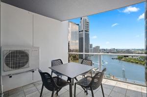 uma varanda com mesa e cadeiras e vista para a água em Brisbane on Felix Luxury Suites em Brisbane