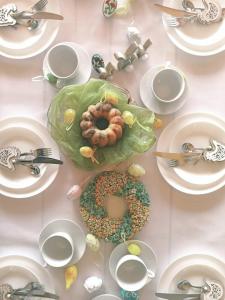 a table with white plates and a donut on it at Domek na Ubocy z widokiem i sauną in Biały Dunajec