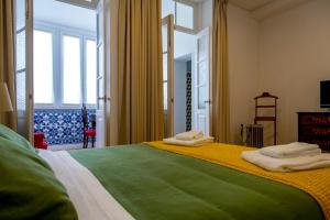 a bedroom with a large bed with towels on it at Casa Velha Guesthouse in Porto