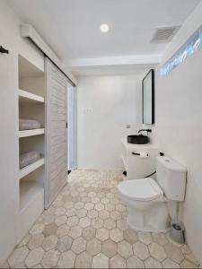 a white bathroom with a toilet in a room at Infinity Villa - BOUTIQUE BEACHFRONT- 2Bed Luxury Family Suite Bingin Beach in Uluwatu