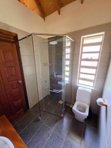 a bathroom with a glass shower and a toilet at Od Kidi Cottages in Migori +22 photos
