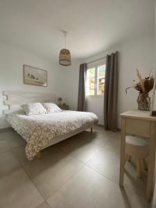 a white bedroom with a bed and a window at Casa Fondale in Santa-Reparata-di-Balagna