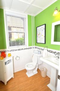 a green bathroom with a toilet and a sink at Aunt Bea's Bungalow - Pet Friendly - Hot Tub - Screen Porch - Wifi - Fenced Yard - King Bed - Town in Berkeley Springs