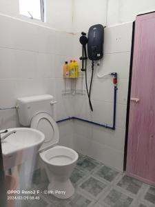 une salle de bain avec toilettes et un téléphone mural dans l'établissement SP 4 Homestay Kuranji Kota Marudu Sabah Malaysia, à Kampong Sorosob