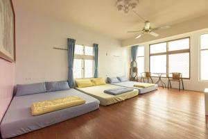 sala de estar con 2 camas y ventilador de techo en Jinshawan B&B en Magong