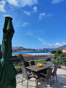 einen Tisch mit Stühlen und einem Sonnenschirm auf einer Terrasse in der Unterkunft Apartments Harriet in Dubrovnik