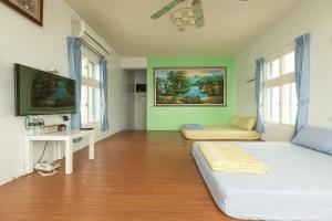 1 dormitorio con 1 cama blanca y TV en Jinshawan B&B en Magong