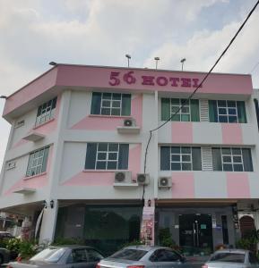 a pink and white building with a sign that reads hottest at 56 HOTEL in Mentekab