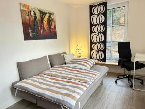 um quarto com uma cama, uma secretária e uma janela em Großzügiges helles Penthouse mit Balkon in ruhiger Lage em Kulmbach