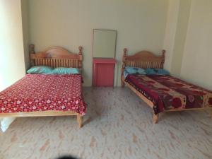 a room with two beds and a mirror at YahVilla Homestay in Baguio