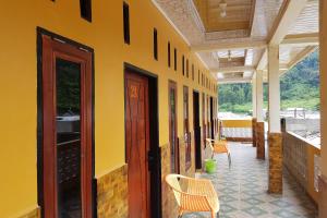 een geel gebouw met 2 stoelen en een patio bij OYO 93771 Sejolie Sibayak in Berastagi