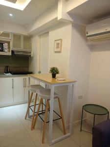 a kitchen with a table and stools in a room at 2 Bedrooms Units Forbes Area 5th Avenue BGC Center in Manila
