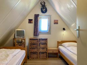 a attic bedroom with two beds and a television at 4 pers. Holiday Home Petra with solarium in Anjum
