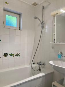 ein Badezimmer mit einer Dusche, einer Badewanne und einem Waschbecken in der Unterkunft 4 pers. Holiday Home Petra with solarium in Anjum