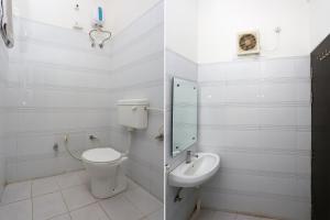 a white bathroom with a toilet and a sink at OYO KN Plaza in Sikandra