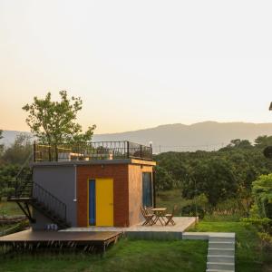 a small house with a yellow door and a deck at Moon Village Khaoyai Holiday Home in Pong Talong