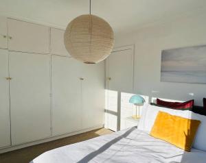 a bedroom with a bed and a large light fixture at The Tassie - Luxury with panoramic water views in Hobart
