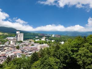 a view of a city with trees and buildings at KAMENOI HOTEL Kusatsu Resort in Kusatsu