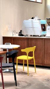 a yellow chair and a table in a room at Centerpoint Hotel & Plaza in Thongsala