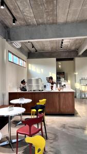 a restaurant with tables and yellow chairs and a counter at Centerpoint Hotel & Plaza in Thongsala