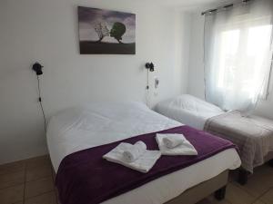 2 łóżka w pokoju z ręcznikami w obiekcie Logis hôtel restaurant Le clos saint loup w mieście Bram