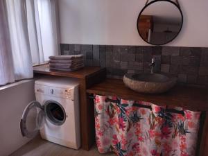 een badkamer met een wasmachine en een wastafel bij Villa vue exceptionnelle in Saint-Leu